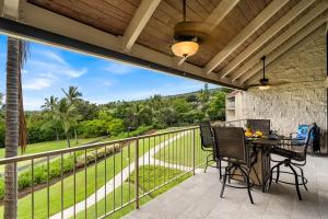 eine Terrasse mit Tisch und Stühlen auf einem Balkon in der Unterkunft Keauhou Punahele B301 in Kailua-Kona