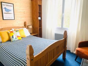 - une chambre avec un lit en bois et une fenêtre dans l'établissement La Maison du Canal, à Rostrenen