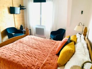 a bedroom with a bed with yellow and orange pillows at La Maison du Canal in Rostrenen