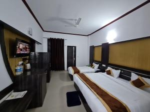 a hotel room with two beds and a tv at Hotel Broadway Katra by Geetanjali Group of Hotels in Katra