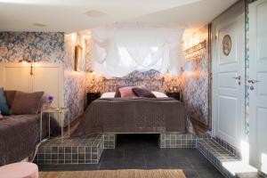 um quarto com uma cama, uma janela e um sofá em Strandvillan Hotell och Bed & Breakfast em Lysekil