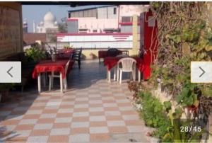 un patio con mesas y sillas en un edificio en Hotel Sai Palace Walking Distance From Taj Mahal--View of Taj Mahal en Agra