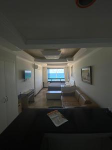 a living room with a couch and a window at Flat Na Barra in Salvador