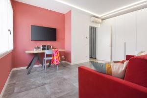 uma sala de estar com uma parede de acento vermelho e um sofá vermelho em LA ROCCA RELAX em Garda