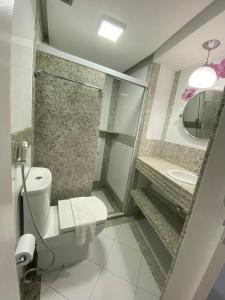 y baño con aseo y lavamanos. en Flat Na Barra, en Salvador