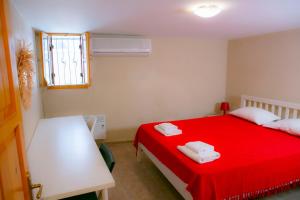 a bedroom with a red bed and a window at annemin harabesi otel in Cesme