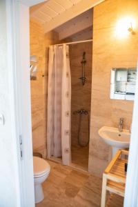 een badkamer met een douche, een toilet en een wastafel bij annemin harabesi otel in Çeşme