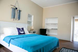 a bedroom with a large bed with a blue blanket at annemin harabesi otel in Çeşme