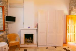 a living room with a fireplace and a white door at annemin harabesi otel in Çeşme