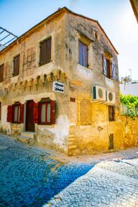 een oud gebouw aan de straatkant bij annemin harabesi otel in Çeşme