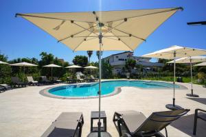 - une piscine avec des chaises et des parasols devant dans l'établissement Europa rooms and restaurant, à Capo Vaticano