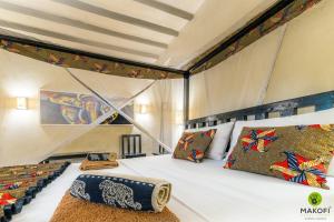 
a bedroom with a large bed and a large window at Makofi Guest House in Nungwi
