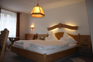 een slaapkamer met een groot bed met witte lakens bij Die Krone in Staufen im Breisgau