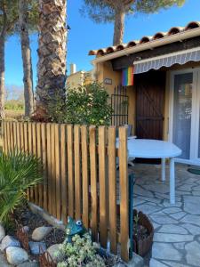 una valla de madera frente a una casa con mesa en Villa 2 z'efs en Cap d'Agde