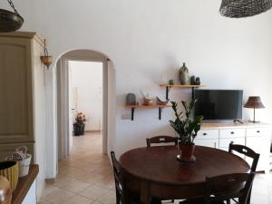 a dining room with a table and a tv at Casa Afrodite in Praiano