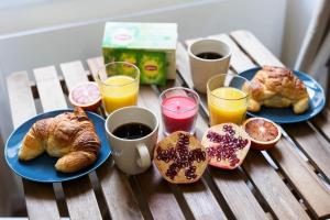 uma mesa com dois pratos de croissants e copos de sumo de laranja em Exotic Stones Hyper Centre Fontaine Moussue em Salon-de-Provence