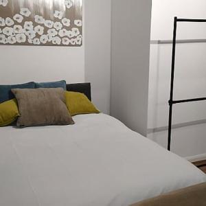 een slaapkamer met een wit bed met gele kussens bij Litherland Apartment in Litherland