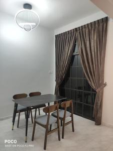 jadalnia ze stołem i krzesłami oraz oknem w obiekcie 55 homestay 4-bedrooms guesthouse in Bukit Bakri Muar Johor w mieście Bakri