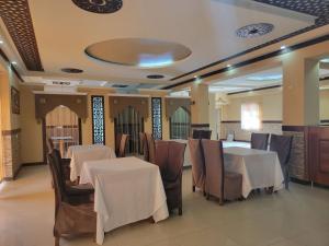 a dining room with tables and chairs and a ceiling at MELODIA Guest House in Bukhara