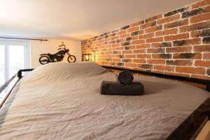 a bed in a room with a brick wall at Bricks Industry Hyper Centre Fontaine Moussue in Salon-de-Provence