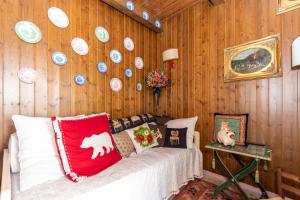 a bedroom with wooden walls with a bed and plates on the wall at Condominio Pien dal Lat in Selva di Cadore