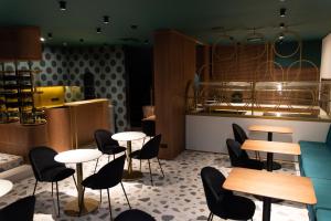 a restaurant with tables and chairs and a kitchen at St. George Hotel in Sofia