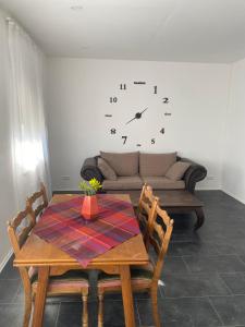 a dining room with a table and a clock on the wall at Pension Kaufungen in Kaufungen