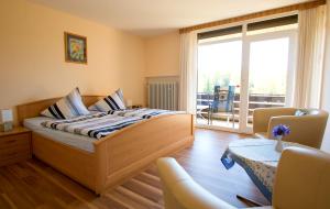 a bedroom with a bed and a balcony at Pension am Hardausee in Suderburg