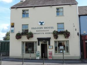 a white building with a sign for a hotel at Falcon Hotel in Carmarthen