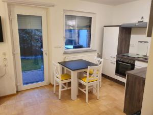 uma cozinha com uma mesa e cadeiras numa cozinha em 37m² 1,5 Zimmer mit Terrasse und super Badezimmer em Tangstedt