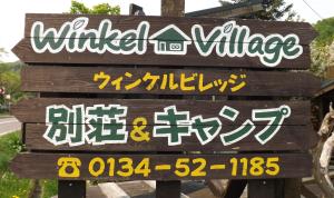 a sign for a winter village withinese writing on it at Winkel Village in Otaru