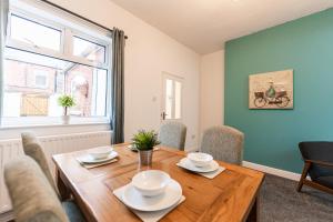 uma sala de jantar com uma mesa de madeira e cadeiras em Brighton House By Horizon Stays em Darlington