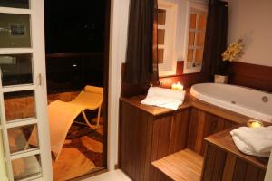 a bathroom with a bath tub and a window at Hotel Willisau in Teresópolis