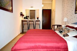 a bedroom with a large red bed and a kitchen at appartamento pontevecchio in Florence