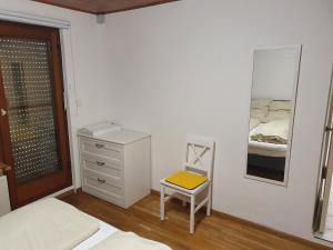 a bedroom with a bed and a mirror and a chair at 37m² 1,5 Zimmer mit Terrasse und super Badezimmer in Tangstedt