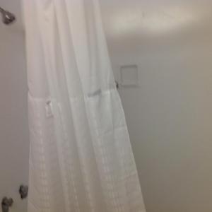 a white shower curtain hanging in a bathroom at Baymont by Wyndham Salem Roanoke Area in Salem