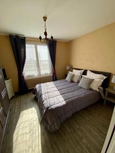 ein Schlafzimmer mit einem großen Bett und einem Fenster in der Unterkunft l'ANNEXE in Verdigny
