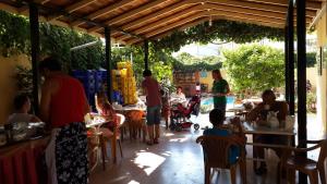 a group of people sitting at tables in a restaurant at Caner Hotel in Kemer