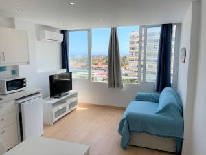 una camera con letto, TV e finestre di Appartment Yumbo Playa del Ingles a Playa del Ingles