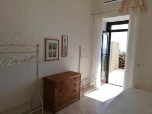 a bedroom with a dresser and a door to a patio at Casa Afrodite in Praiano