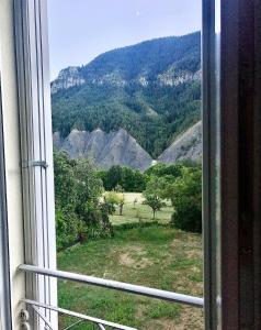 okno z widokiem na góry w obiekcie Le Relais des Cavaliers w mieście Villeneuve-dʼEntraunes
