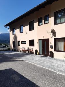 a large white building with a patio at Gästehaus am Walde - Familie Troller in Ledenitzen