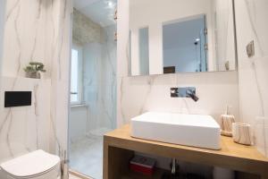 uma casa de banho com um lavatório, um WC e um espelho. em Curcumelli Luxury Suites - ΠΙΝΙΑ em Corfu Town