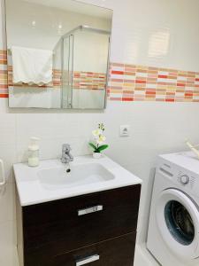 a bathroom with a sink and a washing machine at Marina in Tías +16 photos