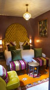 マラケシュにあるRiad Sultan Suleimanのベッドルーム1室(ベッド1台、椅子2脚、シャンデリア付)