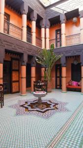 einen Innenhof mit einem Tisch in der Mitte eines Gebäudes in der Unterkunft Riad Sultan Suleiman in Marrakesch