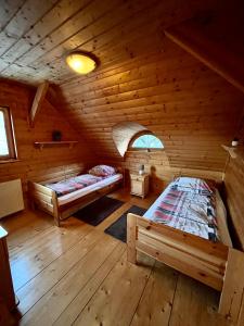 a room with two beds in a wooden cabin at Apartament Lis in Szczyrk