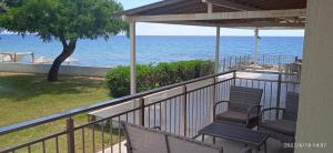a balcony with chairs and a view of the ocean at lemonishouse by the sea 1 in Nea Skioni