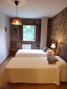 um quarto com 3 camas e uma janela em Turismo Rural Casa del Batlle em Sarroqueta