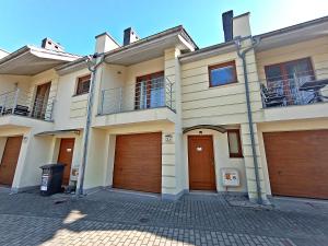a house with two garages and two garage doors at Holiday House by Baltic Home in Świnoujście